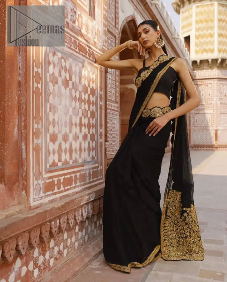 Every saree tells a story! Black is always the reason behind any smile at parties. DeemasFashion also presents a formal saree in black that you can wear at any function or party. The black blouse having sleeveless and strap neckline gives you so soothing and romantic look. Further, the simplicity of the blouse enhances the beauty of the outfit. It comes with a pure black saree which is ornamented with golden embroidery. It is highlighted with tilla, kora, and dabka work on borders. The pallu of the saree is also prominent with golden embridery.