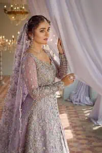 Bold instruments on a bright canvas make a true fashion statement. Introducing a lilac outfit for your Walima day to boost up your day. The front open gown in lilac colour looks as amazing as any bride's dream. It is encapsulated with silver embroidery which contains crystal, tilla, dabka, kora and sequins spray all over. In addition to this, it is highlighted with a sweetheart neckline to enhance the beauty of the gown when combined with full sleeves. It is systemized with silver barcode sharara finished with silver border embroidery that enhances the look of the bride during the day as well as night events. Complete this lilac article with a dupatta which is ornamented with four-sided borders and sequins sprayed all over.