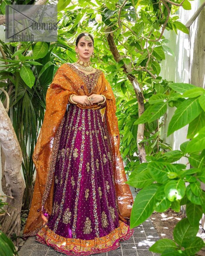 The outfit defines the true essence of allure with its spellbinding magenta hue and intricate details. The blouse is decorated with golden embroidery based on the neckline and sleeves. The sleeves are further enhanced with the embellished handwork. It is Beautifully organized with a magenta lehenga that is again heavily embellished with golden embroidery that is just adding poise to the whole look. Paired along with an orange dupatta decorated with subtly adorned motifs and embellished border that is completing this Mehandi looks wondrously.