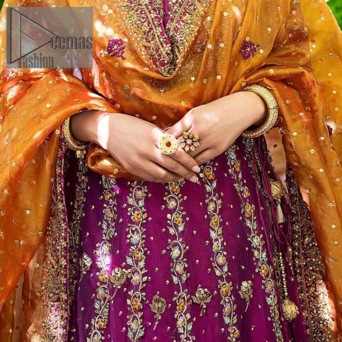 The outfit defines the true essence of allure with its spellbinding magenta hue and intricate details. The blouse is decorated with golden embroidery based on the neckline and sleeves. The sleeves are further enhanced with the embellished handwork. It is Beautifully organized with a magenta lehenga that is again heavily embellished with golden embroidery that is just adding poise to the whole look. Paired along with an orange dupatta decorated with subtly adorned motifs and embellished border that is completing this Mehandi looks wondrously.