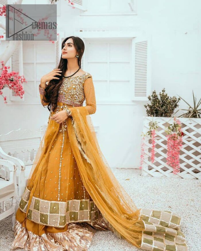 Mustard is just associated and boosts your Mehandi.  Presenting a dreamy mustard frock with a heavily embroidered bodice on a silver base. The bodice is further enhanced with handwork that includes crystal, tilla, kora and dabka work. Furthermore, the boat shape neckline and tiny work on full sleeves have the super style just to boost your day. The bottom is decorated with artistic embroidery that is adding glam to it. The Mehandi look is completed with an artistically crafted frilled lehenga which frill borders displaying the traditional hint of charm. It is coordinated with a dupatta in the same colour that is embellished with four-sided borders as well. 