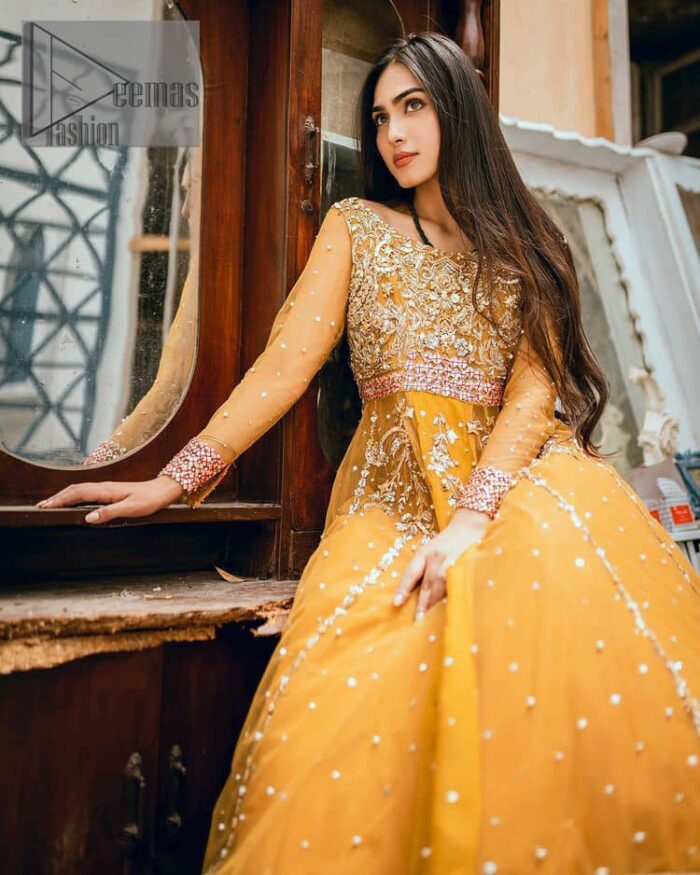 Mustard is just associated and boosts your Mehandi.  Presenting a dreamy mustard frock with a heavily embroidered bodice on a silver base. The bodice is further enhanced with handwork that includes crystal, tilla, kora and dabka work. Furthermore, the boat shape neckline and tiny work on full sleeves have the super style just to boost your day. The bottom is decorated with artistic embroidery that is adding glam to it. The Mehandi look is completed with an artistically crafted frilled lehenga which frill borders displaying the traditional hint of charm. It is coordinated with a dupatta in the same colour that is embellished with four-sided borders as well. 