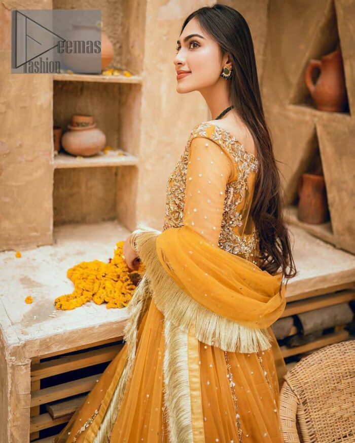 Mustard is just associated and boosts your Mehandi.  Presenting a dreamy mustard frock with a heavily embroidered bodice on a silver base. The bodice is further enhanced with handwork that includes crystal, tilla, kora and dabka work. Furthermore, the boat shape neckline and tiny work on full sleeves have the super style just to boost your day. The bottom is decorated with artistic embroidery that is adding glam to it. The Mehandi look is completed with an artistically crafted frilled lehenga which frill borders displaying the traditional hint of charm. It is coordinated with a dupatta in the same colour that is embellished with four-sided borders as well. 