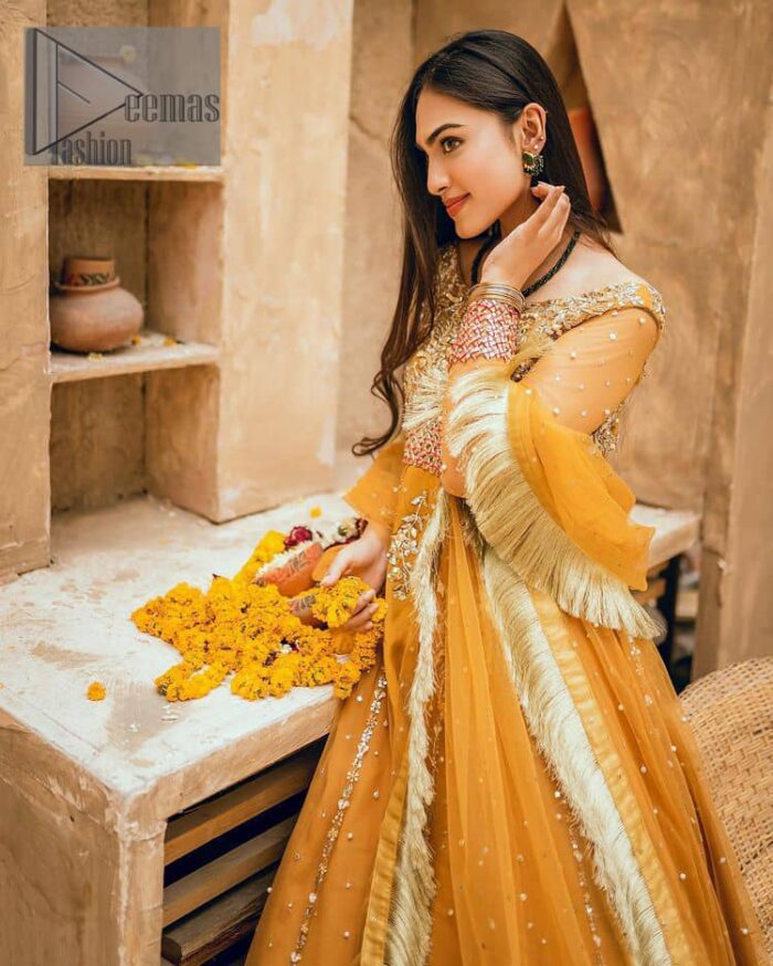 Mustard is just associated and boosts your Mehandi.  Presenting a dreamy mustard frock with a heavily embroidered bodice on a silver base. The bodice is further enhanced with handwork that includes crystal, tilla, kora and dabka work. Furthermore, the boat shape neckline and tiny work on full sleeves have the super style just to boost your day. The bottom is decorated with artistic embroidery that is adding glam to it. The Mehandi look is completed with an artistically crafted frilled lehenga which frill borders displaying the traditional hint of charm. It is coordinated with a dupatta in the same colour that is embellished with four-sided borders as well. 