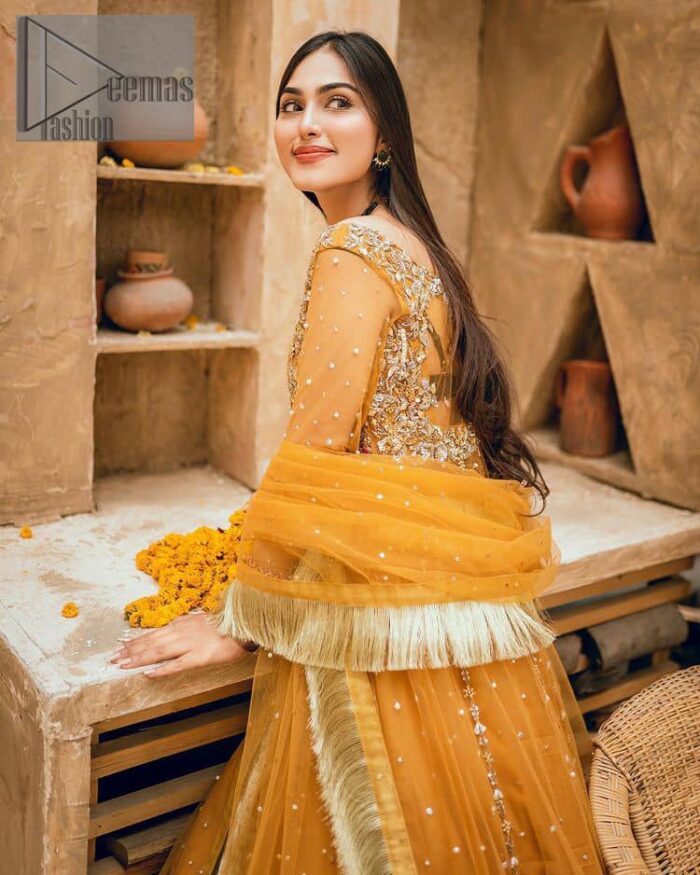 Mustard is just associated and boosts your Mehandi.  Presenting a dreamy mustard frock with a heavily embroidered bodice on a silver base. The bodice is further enhanced with handwork that includes crystal, tilla, kora and dabka work. Furthermore, the boat shape neckline and tiny work on full sleeves have the super style just to boost your day. The bottom is decorated with artistic embroidery that is adding glam to it. The Mehandi look is completed with an artistically crafted frilled lehenga which frill borders displaying the traditional hint of charm. It is coordinated with a dupatta in the same colour that is embellished with four-sided borders as well. 