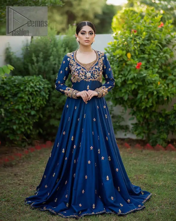 Hues of blues make a funky yet amazing pattern on amazing events. DeemasFashion introduces a navy blue outfit. Starting this article with a navy blue multiple panel frock which is ornamented with golden embroidery. The pattern of embroidery begins with the round neckline which is handsomely embellished with tilla, dabka, kora and Kundan. It is further prominent with full sleeves. The rest of the frock is decorated with floral motifs in a golden hue. The following frock comes with a golden dupatta to complete the admiring look on any day or night event. 