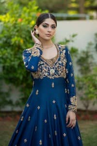 Hues of blues make a funky yet amazing pattern on amazing events. DeemasFashion introduces a navy blue outfit. Starting this article with a navy blue multiple panel frock which is ornamented with golden embroidery. The pattern of embroidery begins with the round neckline which is handsomely embellished with tilla, dabka, kora and Kundan. It is further prominent with full sleeves. The rest of the frock is decorated with floral motifs in a golden hue. The following frock comes with a golden dupatta to complete the admiring look on any day or night event. 