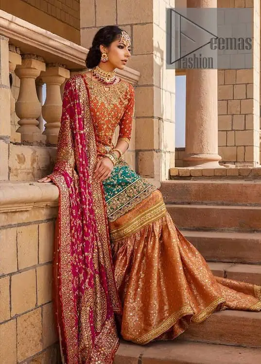 Be a happy and charming bride just like orange is a happy colour. DeemasFashion presents you with an orange short shit that is laboriously embellished with golden embroidery. The base of embroidery starts from the boat shape neckline of the shirt that giving a fully artistic look. In addition to this, it is enhanced with tilla, dabka, kora and Kundan work. The half sleeves of the dhirt also enhance the beauty of the handwork. It is coordinated with orange gharara that is perfect for entimate evening of your Mehandi. Finish this outfit with Pink dupatta that is adorned with ravishing details, the embellished borders represent the craftsmanship of DeemasFashion.