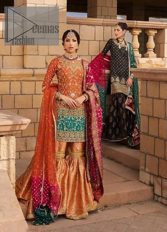 Be a happy and charming bride just like orange is a happy colour. DeemasFashion presents you with an orange short shit that is laboriously embellished with golden embroidery. The base of embroidery starts from the boat shape neckline of the shirt that giving a fully artistic look. In addition to this, it is enhanced with tilla, dabka, kora and Kundan work. The half sleeves of the dhirt also enhance the beauty of the handwork. It is coordinated with orange gharara that is perfect for entimate evening of your Mehandi. Finish this outfit with Pink dupatta that is adorned with ravishing details, the embellished borders represent the craftsmanship of DeemasFashion.