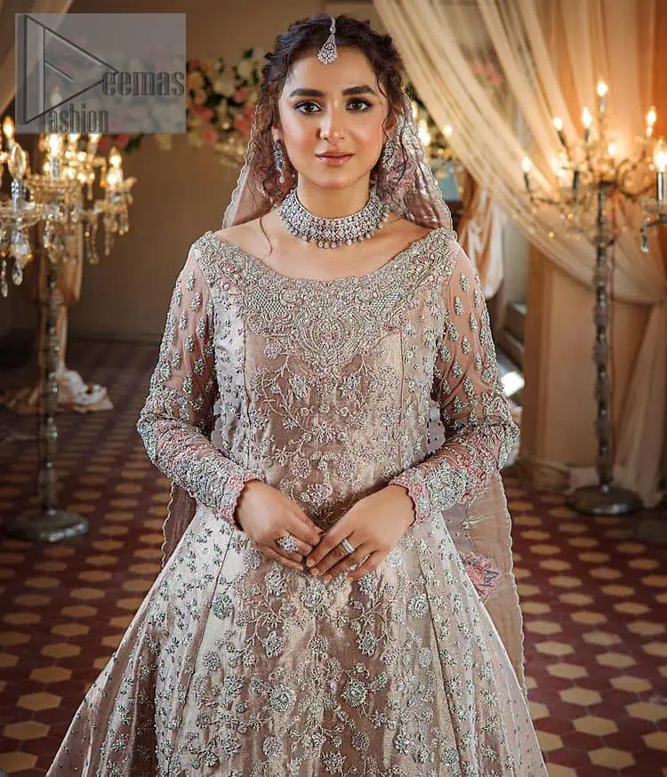 Amplify your style on your Walima day in this stunning light color. DeemasFashion presents the super handsome rose gold outfit for you. First of all, which includes back train maxi in the rose gold colour. It is prominent with the silver embroidery that is encrusted with pearls, silver crystals, kora, dabka and sequins all over highlighting floral patterns. Further, it is emphasized with boat shape neckline and full sleeves that increase the opulent statement of the outfit. It is organized with rose gold sharara which is also embellished with heavy silver embroidery to make your day super dazzling. Finish this look with the rose gold dupatta that is accentuated with sequins and booti spray all over and adorned with a four-sided matha Patti border.