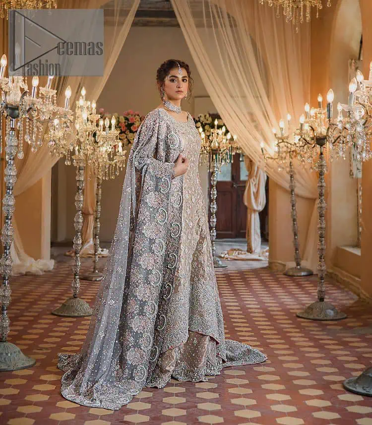 Amplify your style on your Walima day in this stunning light color. DeemasFashion presents the super handsome rose gold outfit for you. First of all, which includes back train maxi in the rose gold colour. It is prominent with the silver embroidery that is encrusted with pearls, silver crystals, kora, dabka and sequins all over highlighting floral patterns. Further, it is emphasized with boat shape neckline and full sleeves that increase the opulent statement of the outfit. It is organized with rose gold sharara which is also embellished with heavy silver embroidery to make your day super dazzling. Finish this look with the rose gold dupatta that is accentuated with sequins and booti spray all over and adorned with a four-sided matha Patti border.