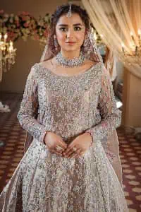 Amplify your style on your Walima day in this stunning light color. DeemasFashion presents the super handsome rose gold outfit for you. First of all, which includes back train maxi in the rose gold colour. It is prominent with the silver embroidery that is encrusted with pearls, silver crystals, kora, dabka and sequins all over highlighting floral patterns. Further, it is emphasized with boat shape neckline and full sleeves that increase the opulent statement of the outfit. It is organized with rose gold sharara which is also embellished with heavy silver embroidery to make your day super dazzling. Finish this look with the rose gold dupatta that is accentuated with sequins and booti spray all over and adorned with a four-sided matha Patti border.