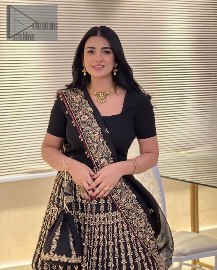 Black is the second way to show romanticness. This black article is attractively rendered with golden embroidery in which details speak for themselves. First of all the blouse in the article is as amazing as in the picture. It is further prominent with tilla, dabka, crystal and kora to enhance the power of black. The boat shape neckline also increases the beauty of the blouse when comes with a sleeveless style. Further, it is paired up with a black can-can lehenga which is heavily embellished with golden embroidery. Complete this look with a black dupatta which is again rendered with four-sided borders and floral motifs all over.