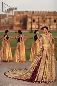 Adorn yourself in the layers of golden that feel rich on the skin. This outfit which is starting with a blouse beautifully laden with golden embroidery that includes kora, dabka, tilla to give you a traditional bride look. It is highlighted with boat shape neckline and super aesthetic full-sleeves to enhance your emotion of you on your Big Day. It is systematically arranged with a two-tone lehenga which is prominent with back train style and heavily adorned with embroidery. Finish this article with a golden scalloped dupatta that is embellished with four-sided borders and sequins sprayed all over. 