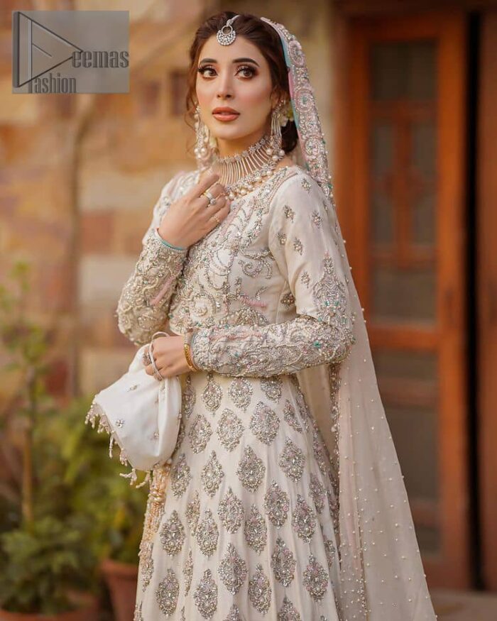 Ivory is effortlessly snappy and fun with the essence of pop. Introducing the Walima outfit for the happiest bride. Starting the outfit with an astonishing blouse having golden embroidery which includes kora, dabka, tilla and Kundan to make this outfit a unique piece of fun. Further, it is enhanced with boat shape neckline with intimate full sleeves. It is beautifully organized with a can-can lehenga in the same colour to embrace the magic of love. The floral embroidery on the lehenga gives a super aesthetic feeling to the outfit. Finish this look with the handsome dupatta in the same hue having a four-sided embellished border and sequins sprayed all over to show the essence of pop.