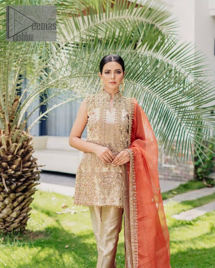 Envelop yourself into a dazzling love affair. The unique article in ivory colour just highlighted you at any event. The short shirt of the article is handsomely decorated with golden embroidery which includes kora, dabka, tilla, Kundan and Sitara work to make your event blazing and dazzling.  It is enhanced with a collared neckline to make this outfit more formal when come with a sleeveless style. Further, it is coordinated with pant which is embellished with golden embroidery. Last but not least piece the dupatta comes in rust colour having four-sided embellished borders to encapsulate you in stars.