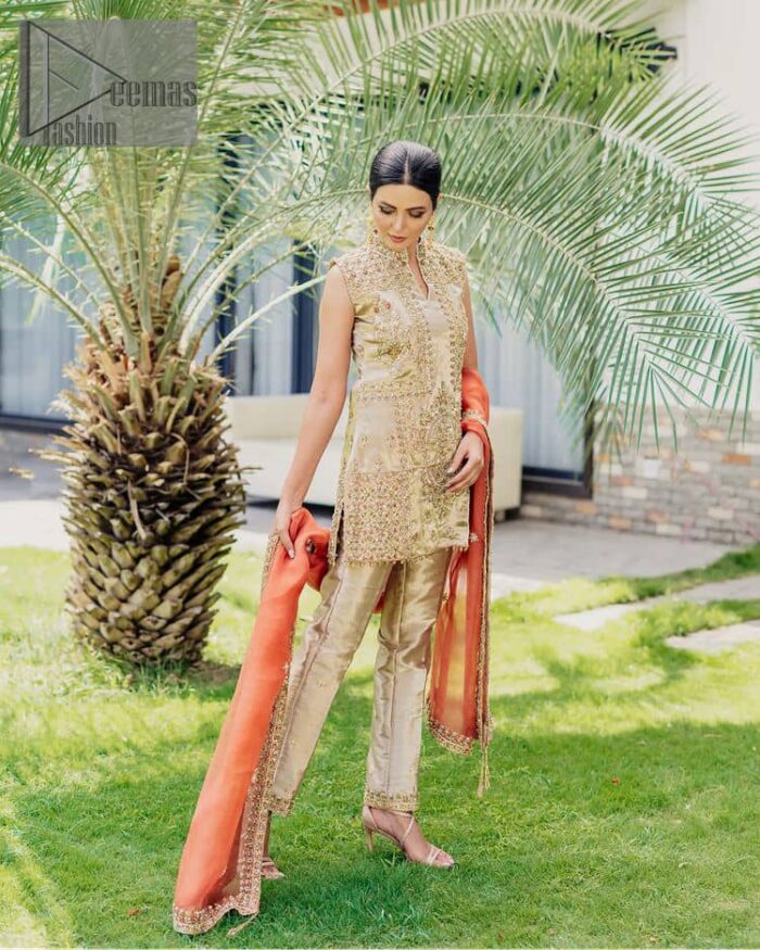 Envelop yourself into a dazzling love affair. The unique article in ivory colour just highlighted you at any event. The short shirt of the article is handsomely decorated with golden embroidery which includes kora, dabka, tilla, Kundan and Sitara work to make your event blazing and dazzling.  It is enhanced with a collared neckline to make this outfit more formal when come with a sleeveless style. Further, it is coordinated with pant which is embellished with golden embroidery. Last but not least piece the dupatta comes in rust colour having four-sided embellished borders to encapsulate you in stars.