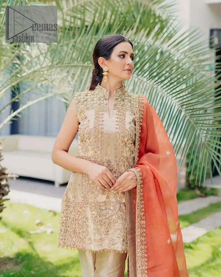 Envelop yourself into a dazzling love affair. The unique article in ivory colour just highlighted you at any event. The short shirt of the article is handsomely decorated with golden embroidery which includes kora, dabka, tilla, Kundan and Sitara work to make your event blazing and dazzling. It is enhanced with a collared neckline to make this outfit more formal when come with a sleeveless style. Further, it is coordinated with pant which is embellished with golden embroidery. Last but not least piece the dupatta comes in rust colour having four-sided embellished borders to encapsulate you in stars.