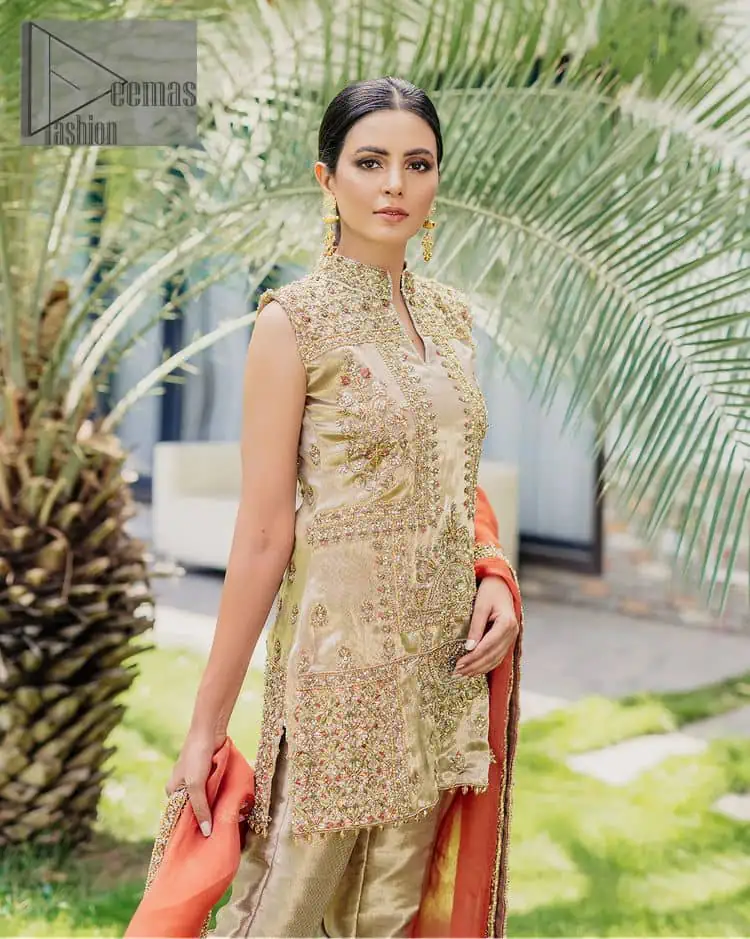 Envelop yourself into a dazzling love affair. The unique article in ivory colour just highlighted you at any event. The short shirt of the article is handsomely decorated with golden embroidery which includes kora, dabka, tilla, Kundan and Sitara work to make your event blazing and dazzling. It is enhanced with a collared neckline to make this outfit more formal when come with a sleeveless style. Further, it is coordinated with pant which is embellished with golden embroidery. Last but not least piece the dupatta comes in rust colour having four-sided embellished borders to encapsulate you in stars.