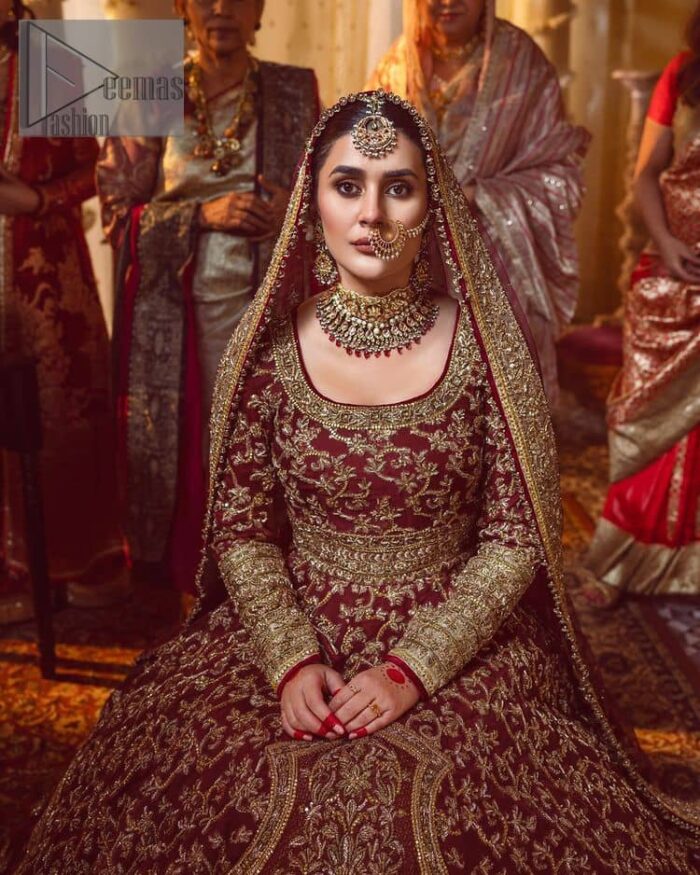 Take me to your heart, for it's there that I belong. A pure outfit base in maroon as a canvas to meticulously designed golden bloomings all over to show the real-time magic of tilla, kora, dabka and zardozi. The round neckline of the traditional pishwas highlighted the incrusted beauty of the outfit. Further, the full sleeve of the following pishwas is wearable art on your big day. It is systemized with a heavy lehenga to give you a more traditional look. Complete this maroon outfit with a dupatta in the same hue having four-sided embellished borders and sequins sprayed all over to show the colour of love.