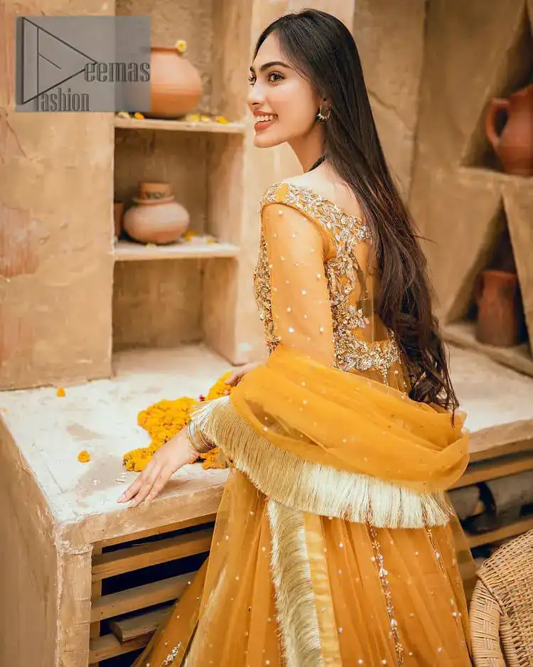 Mustard is just associated and boosts your Mehandi.  Presenting a dreamy mustard frock with a heavily embroidered bodice on a silver base. The bodice is further enhanced with handwork that includes crystal, tilla, kora and dabka work. Furthermore, the boat shape neckline and tiny work on full sleeves have the super style just to boost your day. The bottom is decorated with artistic embroidery that is adding glam to it. The Mehandi look is completed with an artistically crafted frilled lehenga which frill borders displaying the traditional hint of charm. It is coordinated with a dupatta in the same colour that is embellished with four-sided borders as well.