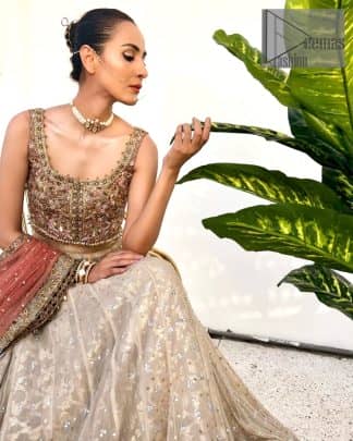 The perfect outfit for walima to enhance your glow. Starting this article with a dream rust blouse having a strap neckline and prominent sleeveless style to embrace the romantic culture. The following blouse is fully embellished with golden embroidery that is prominent with tilla, dabka, kora, pearls and sequins spray to fulfil your dreamy look. It is coordinated with an ivory can-can lehenga whose border is again rendered with golden embroidery and sequins sprayed all over to continue the look. Complete this outfit with a rust dupatta which is embellished with four-sided borders and sequins sprayed all over to enhance the glow of the bride.
