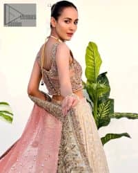 The perfect outfit for walima to enhance your glow. Starting this article with a dream rust blouse having a strap neckline and prominent sleeveless style to embrace the romantic culture. The following blouse is fully embellished with golden embroidery that is prominent with tilla, dabka, kora, pearls and sequins spray to fulfil your dreamy look. It is coordinated with an ivory can-can lehenga whose border is again rendered with golden embroidery and sequins sprayed all over to continue the look. Complete this outfit with a rust dupatta which is embellished with four-sided borders and sequins sprayed all over to enhance the glow of the bride.