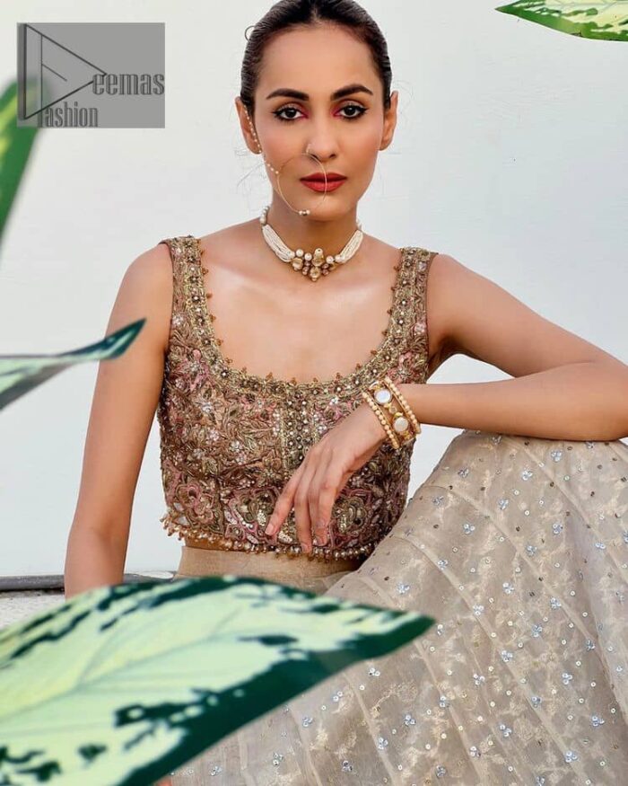 The perfect outfit for walima to enhance your glow. Starting this article with a dream rust blouse having a strap neckline and prominent sleeveless style to embrace the romantic culture. The following blouse is fully embellished with golden embroidery that is prominent with tilla, dabka, kora, pearls and sequins spray to fulfil your dreamy look. It is coordinated with an ivory can-can lehenga whose border is again rendered with golden embroidery and sequins sprayed all over to continue the look. Complete this outfit with a rust dupatta which is embellished with four-sided borders and sequins sprayed all over to enhance the glow of the bride.