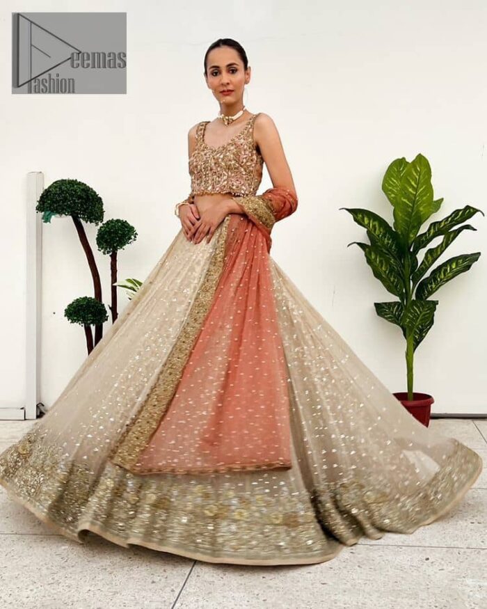 The perfect outfit for walima to enhance your glow. Starting this article with a dream rust blouse having a strap neckline and prominent sleeveless style to embrace the romantic culture. The following blouse is fully embellished with golden embroidery that is prominent with tilla, dabka, kora, pearls and sequins spray to fulfil your dreamy look. It is coordinated with an ivory can-can lehenga whose border is again rendered with golden embroidery and sequins sprayed all over to continue the look. Complete this outfit with a rust dupatta which is embellished with four-sided borders and sequins sprayed all over to enhance the glow of the bride.