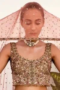 The perfect outfit for walima to enhance your glow. Starting this article with a dream rust blouse having a strap neckline and prominent sleeveless style to embrace the romantic culture. The following blouse is fully embellished with golden embroidery that is prominent with tilla, dabka, kora, pearls and sequins spray to fulfil your dreamy look. It is coordinated with an ivory can-can lehenga whose border is again rendered with golden embroidery and sequins sprayed all over to continue the look. Complete this outfit with a rust dupatta which is embellished with four-sided borders and sequins sprayed all over to enhance the glow of the bride.