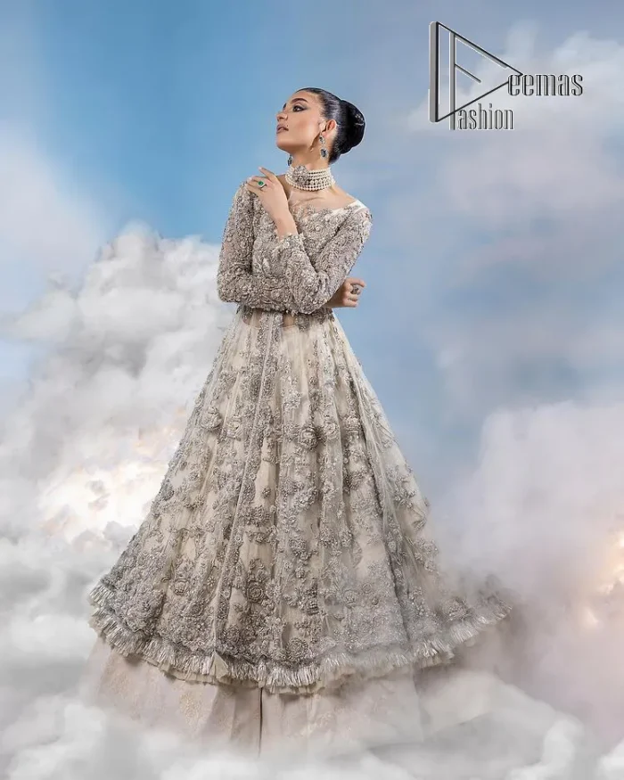 The mind wears the colours of the soul, as a beige of those of his master. Starting this nikah outfit with a beige frilled maxi which is laboriously hand-rendered with silver embroidery to fulfil the fairy dream of every bride. Furthermore, it is enhanced with tilla, dabka, kora and crystal which magnifies the beauty of this nikah outfit. The illusion neckline looks as amazing when comes with full sleeves as the moon with stars. The maxi of this nikah outfit is systemized with a lehenga in the same colour which is proof of uniqueness. Complete this nikah outfit with a dupatta in the same colour having a four-sided embellished border and sequins sprayed all over.    