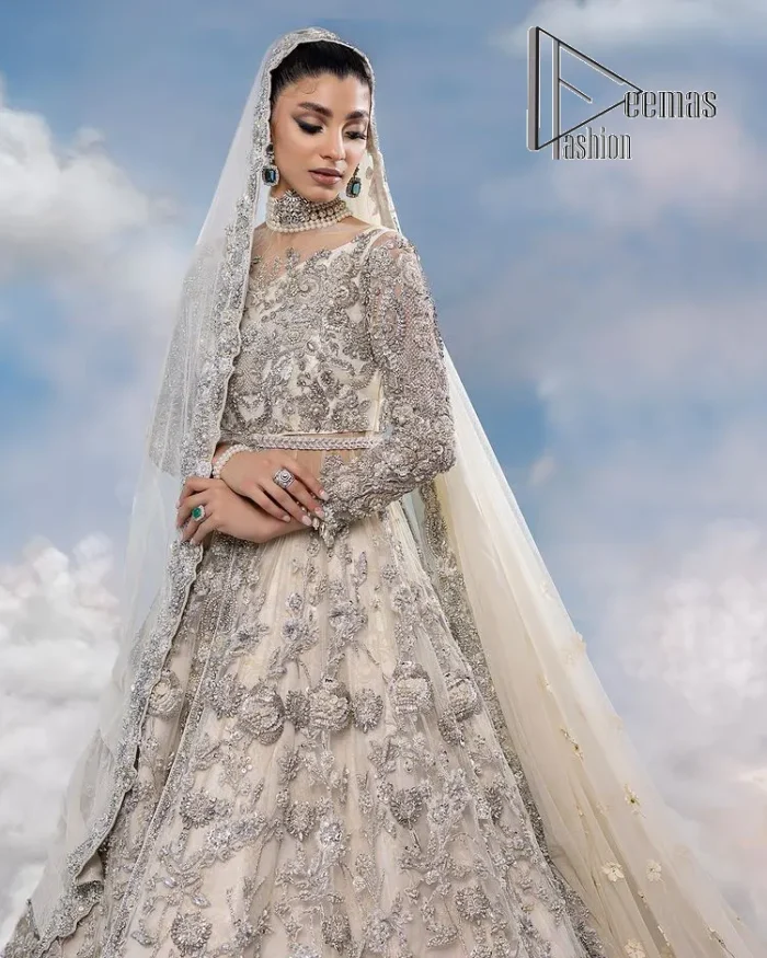 The mind wears the colours of the soul, as a beige of those of his master. Starting this nikah outfit with a beige frilled maxi which is laboriously hand-rendered with silver embroidery to fulfil the fairy dream of every bride. Furthermore, it is enhanced with tilla, dabka, kora and crystal which magnifies the beauty of this nikah outfit. The illusion neckline looks as amazing when comes with full sleeves as the moon with stars. The maxi of this nikah outfit is systemized with a lehenga in the same colour which is proof of uniqueness. Complete this nikah outfit with a dupatta in the same colour having a four-sided embellished border and sequins sprayed all over.    