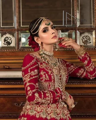 Happiness and confidence are the prettiest things that are associated with your wedding outfit. DeemasFashion presents this Pakistani reception wear in deep red colour. The deep red heavy maxi of this Pakistani reception wear is gorgeously adorned with a golden embroidery which is further enhanced with tilla, dabka, and kora. The boat shape neckline speaks of the boldness of the outfit. The following maxi is paired up with maroon sharara whose border is also embellished. Out and out of this Pakistani reception wears a dupatta in the same colour which is adorned with a four-sided border. Further, it is decorated with sequins sprayed all over.