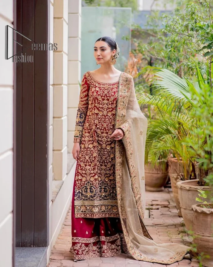 Embrace yourself with deep red on your big day. This deep red long shirt is meticulously hand-rendered with light golden embroidery which is further enhanced with tilla, dabka, kora and zardozi. The boat shape neckline of the long shirt is uniquely designed with full sleeves. This nikah wear is paired up with deep red sharara having embellished borders and ting floral motifs. Complete this nikah wear with a light fawn dupatta having four-sided embellished borders and tiny floral motifs all over to fulfil your dreams for your big day.
