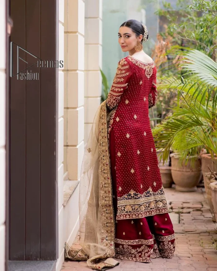 Embrace yourself with deep red on your big day. This deep red long shirt is meticulously hand-rendered with light golden embroidery which is further enhanced with tilla, dabka, kora and zardozi. The boat shape neckline of the long shirt is uniquely designed with full sleeves. This nikah wear is paired up with deep red sharara having embellished borders and ting floral motifs. Complete this nikah wear with a light fawn dupatta having four-sided embellished borders and tiny floral motifs all over to fulfil your dreams for your big day.