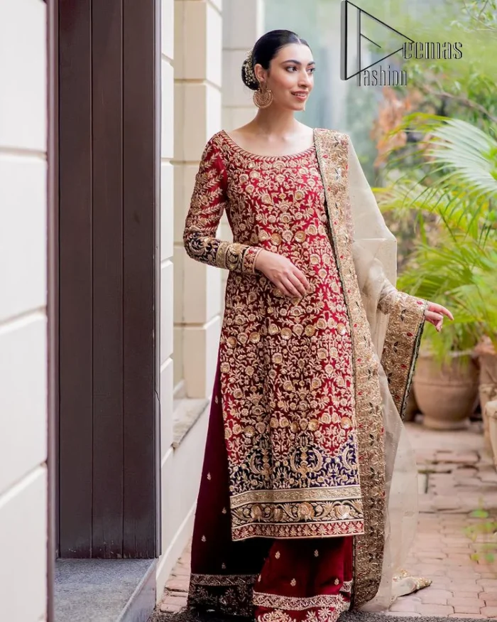 Embrace yourself with deep red on your big day. This deep red long shirt is meticulously hand-rendered with light golden embroidery which is further enhanced with tilla, dabka, kora and zardozi. The boat shape neckline of the long shirt is uniquely designed with full sleeves. This nikah wear is paired up with deep red sharara having embellished borders and ting floral motifs. Complete this nikah wear with a light fawn dupatta having four-sided embellished borders and tiny floral motifs all over to fulfil your dreams for your big day.