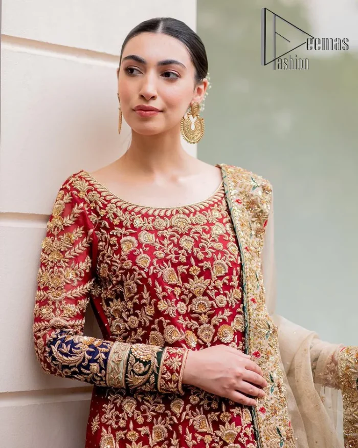 Embrace yourself with deep red on your big day. This deep red long shirt is meticulously hand-rendered with light golden embroidery which is further enhanced with tilla, dabka, kora and zardozi. The boat shape neckline of the long shirt is uniquely designed with full sleeves. This nikah wear is paired up with deep red sharara having embellished borders and ting floral motifs. Complete this nikah wear with a light fawn dupatta having four-sided embellished borders and tiny floral motifs all over to fulfil your dreams for your big day.