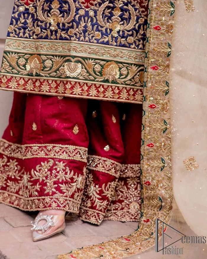 Embrace yourself with deep red on your big day. This deep red long shirt is meticulously hand-rendered with light golden embroidery which is further enhanced with tilla, dabka, kora and zardozi. The boat shape neckline of the long shirt is uniquely designed with full sleeves. This nikah wear is paired up with deep red sharara having embellished borders and ting floral motifs. Complete this nikah wear with a light fawn dupatta having four-sided embellished borders and tiny floral motifs all over to fulfil your dreams for your big day.