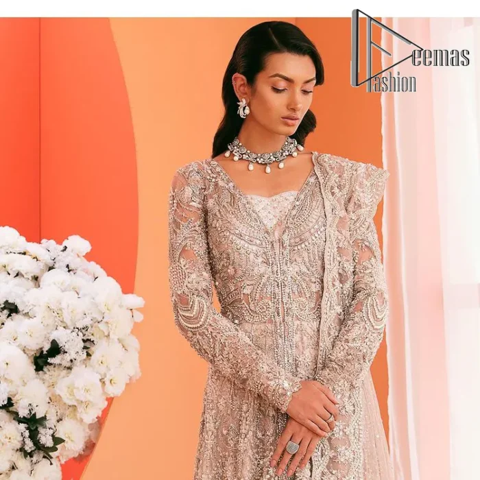 A magical evening, the moon reflects your face of you!  This romantic beige-pink front open maxi is laboriously decorated with silver embroidery to make your nikah dress super magical. The hand-rendered involves kora, dabka, tilla and crystal. Further, the V shape neckline and full sleeves of this nikah dress are as amazing as ever the bride wants on her day. It is coordinated with a back train lehenga which is specially designed with a scalloped style and also heavily ornamented with embroidery. Completed this Nikah dress with a scalloped dupatta in the same colour which is again embellished with four-sided borders and sequins sprayed all over to make your evening super magical.