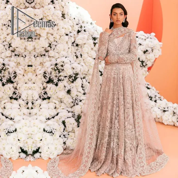 A magical evening, the moon reflects your face of you!  This romantic beige-pink front open maxi is laboriously decorated with silver embroidery to make your nikah dress super magical. The hand-rendered involves kora, dabka, tilla and crystal. Further, the V shape neckline and full sleeves of this nikah dress are as amazing as ever the bride wants on her day. It is coordinated with a back train lehenga which is specially designed with a scalloped style and also heavily ornamented with embroidery. Completed this Nikah dress with a scalloped dupatta in the same colour which is again embellished with four-sided borders and sequins sprayed all over to make your evening super magical.