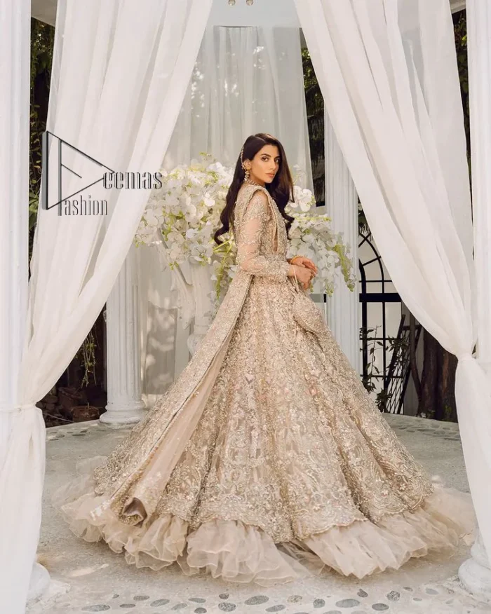 Begin your new life by wearing a dreamy nikah outfit of deemasFashion. Introduce this nikkah outfit with a light fawn frilled heavy maxi that is laboriously hand-rendered with silver and the same colour embroidery that enhances tilla, dabka, kora and crystal. The boat shape neckline and full sleeves of this maxi also add memorable beauty to your amazing Qabool Hai moment. The maxi of this nikah wear is systemized with a dupatta in the same colour which is ornamented with four-sided borders and sequins sprayed all over to enhance the attractiveness of the nikah outfit.