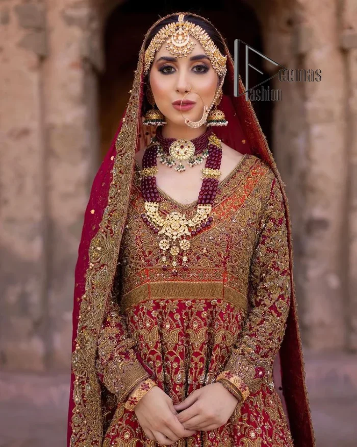 Happy is the bride the maroon shines on. Initiate this Pakistani reception outfit with a maroon heavy Anarkali which is sumptuously hand-rendered with golden embroidery that includes tilla, dabka, kora and Kundan. The V shape neckline of this Pakistani reception outfit exquisitely comes with full sleeves. It is paired up with rust farshi lehenga whose border is again adorned with golden embroidery. Finish this Pakistani reception outfit with a dupatta with a four-sided embellished border and sequins sprayed all over to put a maroonish shine on your big day.