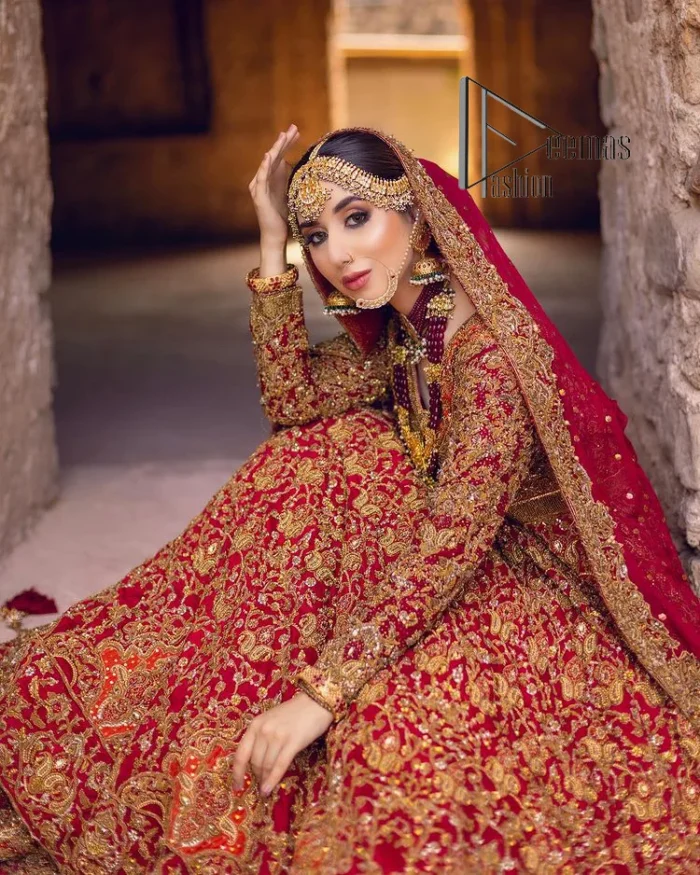 Happy is the bride the maroon shines on. Initiate this Pakistani reception outfit with a maroon heavy Anarkali which is sumptuously hand-rendered with golden embroidery that includes tilla, dabka, kora and Kundan. The V shape neckline of this Pakistani reception outfit exquisitely comes with full sleeves. It is paired up with rust farshi lehenga whose border is again adorned with golden embroidery. Finish this Pakistani reception outfit with a dupatta with a four-sided embellished border and sequins sprayed all over to put a maroonish shine on your big day.