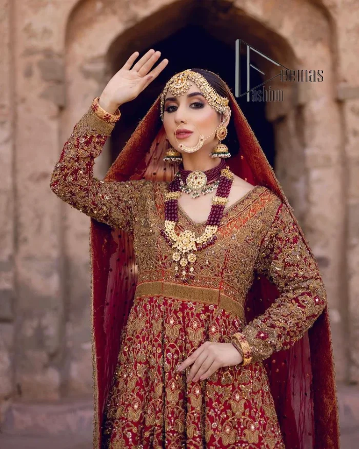 Happy is the bride the maroon shines on. Initiate this Pakistani reception outfit with a maroon heavy Anarkali which is sumptuously hand-rendered with golden embroidery that includes tilla, dabka, kora and Kundan. The V shape neckline of this Pakistani reception outfit exquisitely comes with full sleeves. It is paired up with rust farshi lehenga whose border is again adorned with golden embroidery. Finish this Pakistani reception outfit with a dupatta with a four-sided embellished border and sequins sprayed all over to put a maroonish shine on your big day.