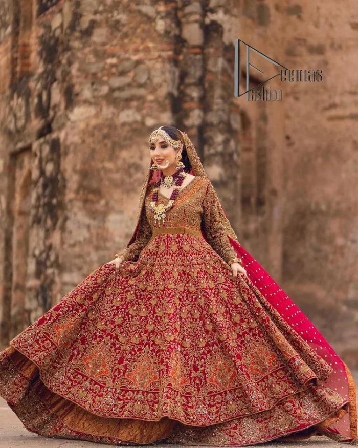 Happy is the bride the maroon shines on. Initiate this Pakistani reception outfit with a maroon heavy Anarkali which is sumptuously hand-rendered with golden embroidery that includes tilla, dabka, kora and Kundan. The V shape neckline of this Pakistani reception outfit exquisitely comes with full sleeves. It is paired up with rust farshi lehenga whose border is again adorned with golden embroidery. Finish this Pakistani reception outfit with a dupatta with a four-sided embellished border and sequins sprayed all over to put a maroonish shine on your big day.