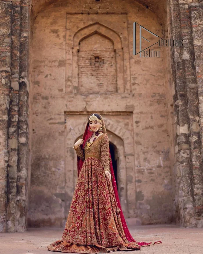 Happy is the bride the maroon shines on. Initiate this Pakistani reception outfit with a maroon heavy Anarkali which is sumptuously hand-rendered with golden embroidery that includes tilla, dabka, kora and Kundan. The V shape neckline of this Pakistani reception outfit exquisitely comes with full sleeves. It is paired up with rust farshi lehenga whose border is again adorned with golden embroidery. Finish this Pakistani reception outfit with a dupatta with a four-sided embellished border and sequins sprayed all over to put a maroonish shine on your big day.