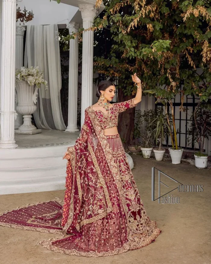 Make your day more lovely by wearing maroon colours. Maroon is just the star among all colours for the bride's Big day. So, DeemasFashion presents this maroon Pakistani reception outfit which begins with a traditional blouse that is meticulously adorned with light golden embroidery. Further, it is enhanced with tilla, dabka, kora and zardozi to make your day more remarkable. The three-quarter sleeves of the blouse add more beauty to this outfit. This Pakistani reception outfit is paired up with a can-can lehenga which is again heavily ornamented with light golden embroidery. Finish this article with a dupatta that is embellished with a four-sided border to fulfil your artistic look.
