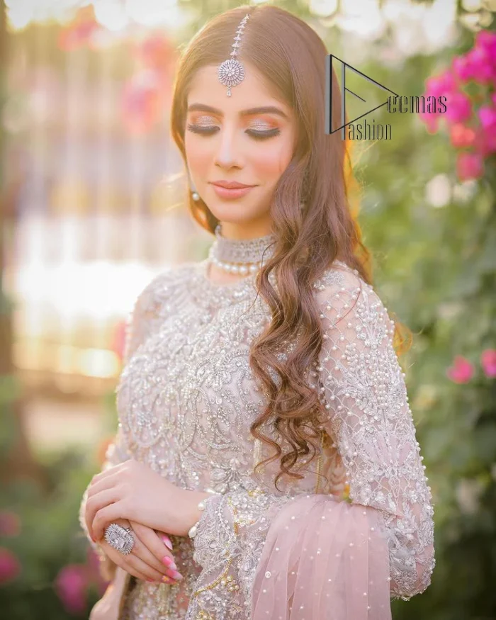 Introducing the mauve nikah outfit which begins with a short shirt that is meticulously and laboriously hand-rendered with silver embroidery which is embellished with tilla, dabka, and Sitara. Furthermore, the full sleeves of this nikah outfit are more attractive when come with a round-shaped neckline. It is coordinated with a fish-style heavy lehenga which is again ornamented with silver embroidery. Complete this nikah wear with a scalloped dupatta which is embellished with four-sided borders and sequins sprayed all over.
