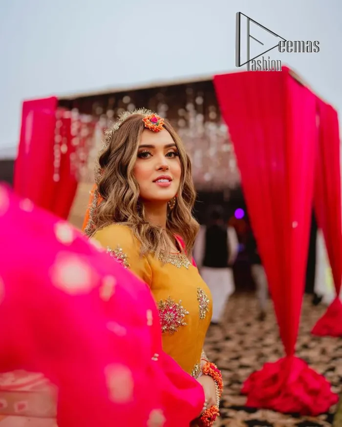We seek outside the wonders we carry inside us. A mehndi dress in the mustard shirt is enhanced with gorgeous gota work. and is designed using the floral technique in pink and golden which is incrusted with tilla, dabka, kora and Sitara. The border of the mustard shirt is heavily ornamented with golden embroidery. The round neckline enhances the beauty of this mehndi dress when comes with three-quarter sleeves. It is paired up with mustard Gharara which is super simple and its border is encapsulated with Kiran. Complete this mehndi dress with a pink dupatta having ting floral motifs all over.
