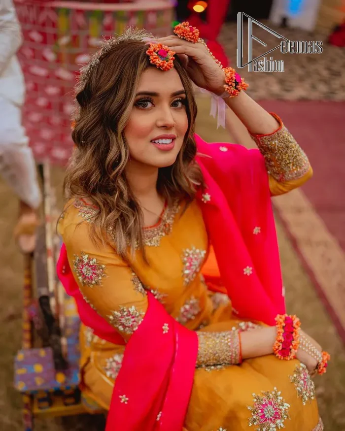 We seek outside the wonders we carry inside us. A mehndi dress in the mustard shirt is enhanced with gorgeous gota work. and is designed using the floral technique in pink and golden which is incrusted with tilla, dabka, kora and Sitara. The border of the mustard shirt is heavily ornamented with golden embroidery. The round neckline enhances the beauty of this mehndi dress when comes with three-quarter sleeves. It is paired up with mustard Gharara which is super simple and its border is encapsulated with Kiran. Complete this mehndi dress with a pink dupatta having ting floral motifs all over.